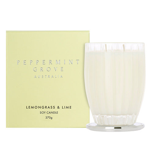 Lemongrass & Lime Candle with silver lid in custom glass, in front of packaging.