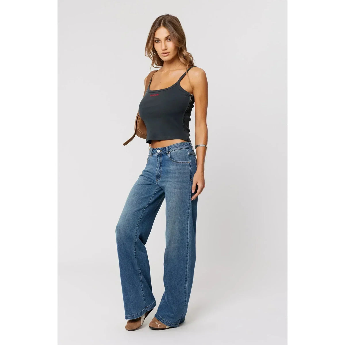 Woman wearing wide leg high rise jeans, showing how jean rise fits the body