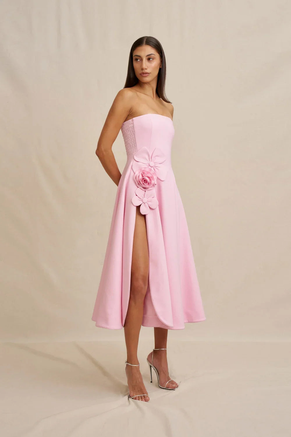 Flora Strapless Dress in pale pink crepe, with a fitted bodice, flared midi skirt, and dimensional floral appliqués.